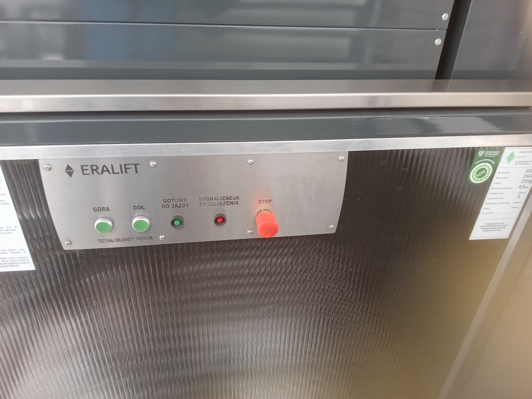 Panel sterowania windy z przyciskami GÓRA, DÓŁ, STOP oraz sygnalizacją gotowości do jazdy i przeciążenia, marki ERALIFT.