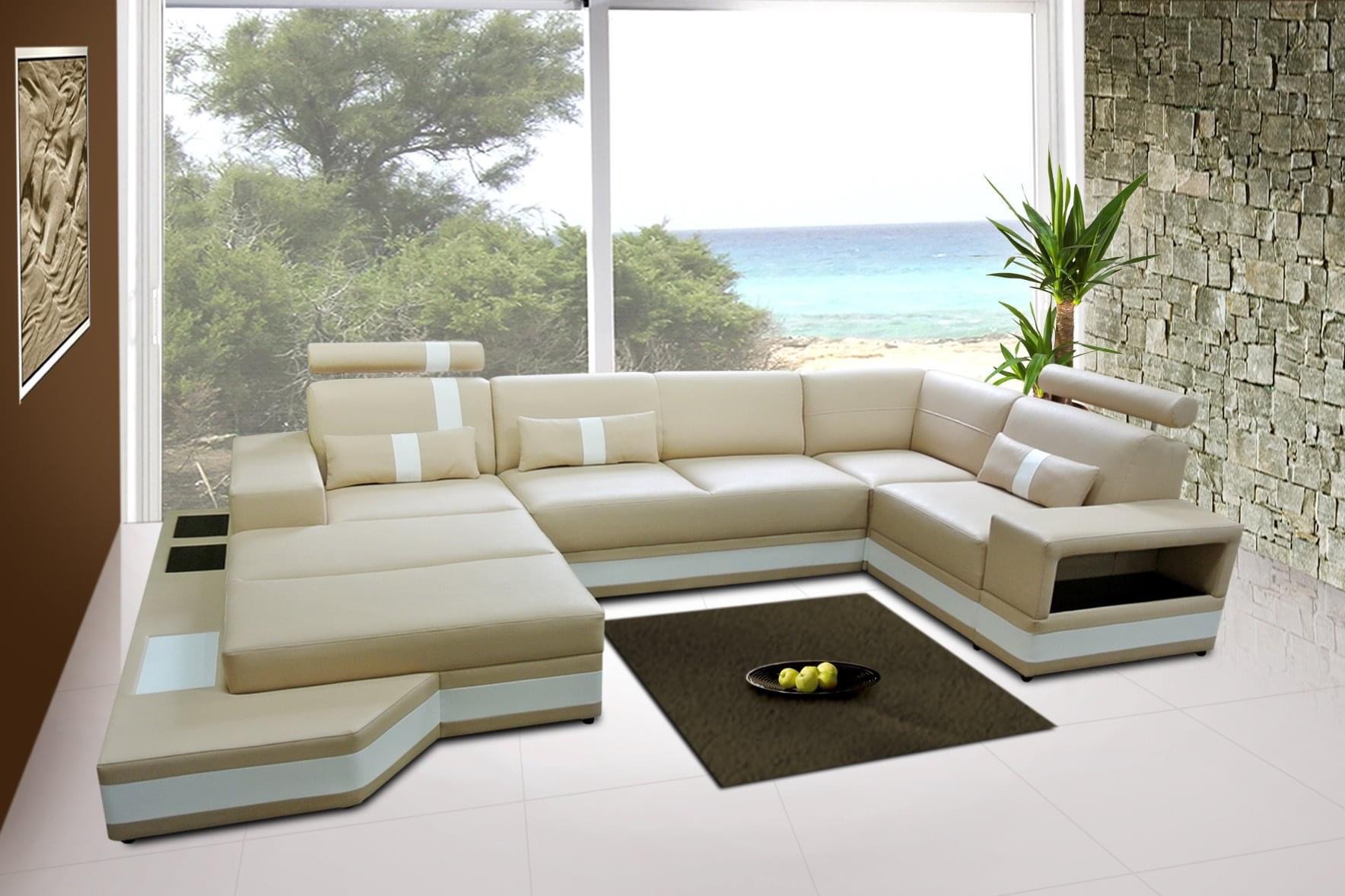 Beżowy narożnik z białymi akcentami i regulowanymi zagłówkami w jasnym salonie z widokiem na morze i roślinność, na podłodze dywanik z owocami.