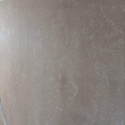 MAT-BUD Usługi ogólnobudowlane - Beżowa ściana z dekoracyjnym wzorem przypominającym marmur, świeżo po malowaniu, widoczne przejścia kolorystyczne i delikatna faktura.