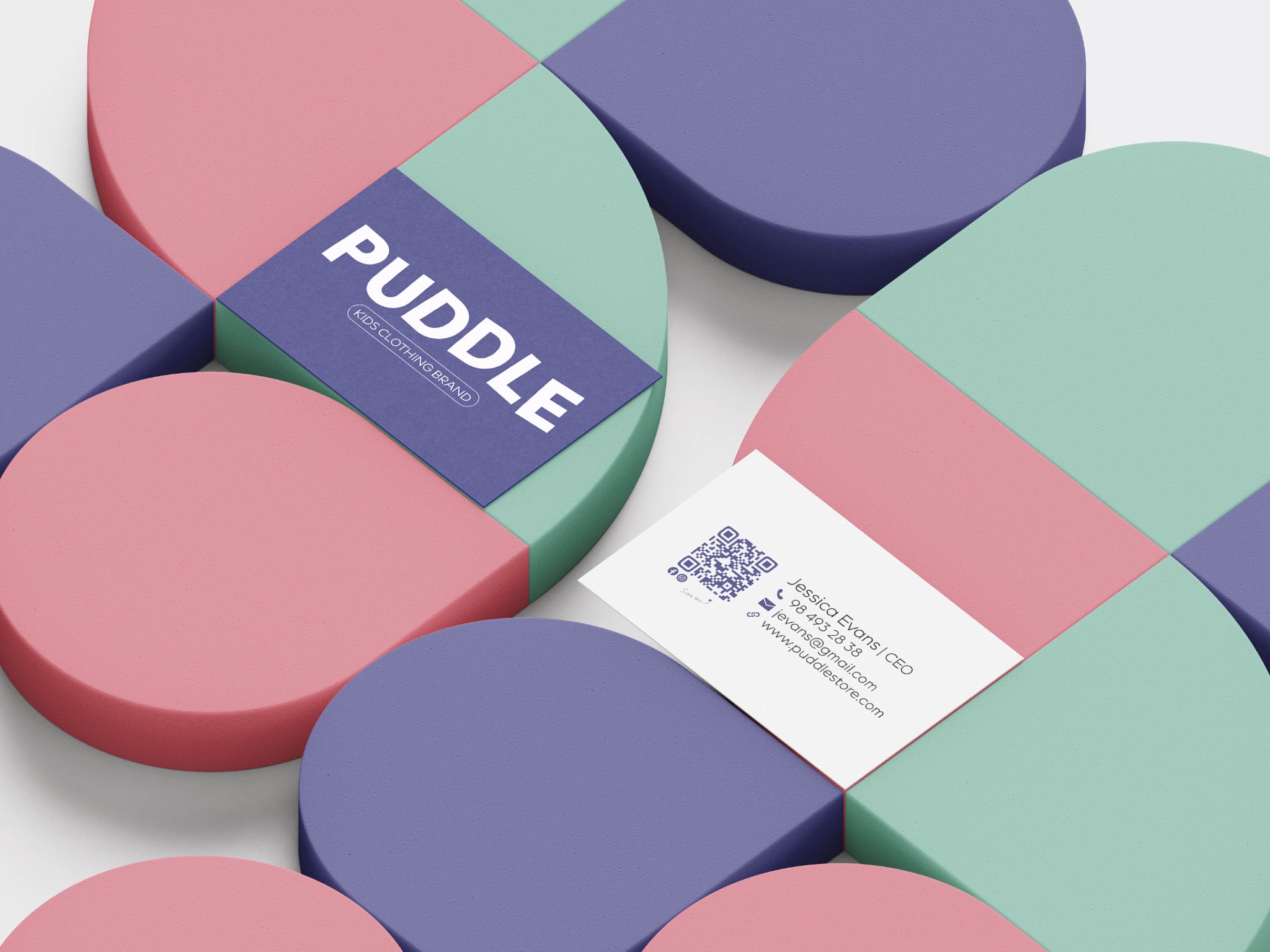 Wizytówka i etykieta marki odzieżowej dla dzieci 'Puddle' na tle pastelowych elementów w kształcie zaokrąglonych kwadratów.
