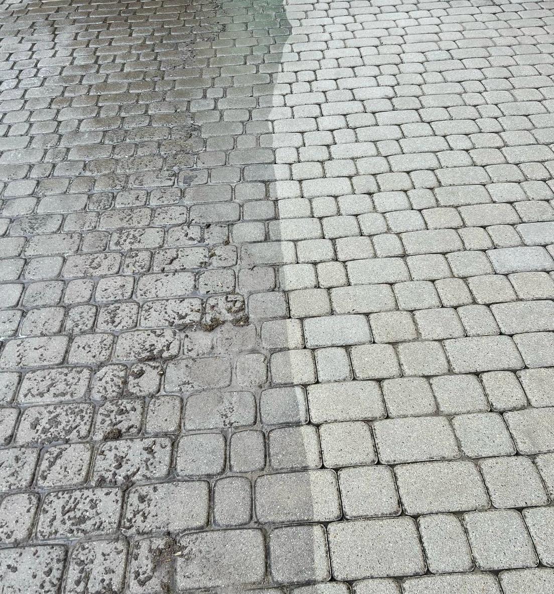 Częściowo wyczyszczona kostka brukowa z widoczną różnicą w kolorze i zabrudzeniach, ukazująca efekt przed i po czyszczeniu.