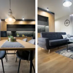 Nowoczesne wnętrze: drewniana kuchnia z czarnym blatem, stół z szarymi krzesłami i szary narożnik z czarnym stolikiem kawowym na drewnianej podłodze.