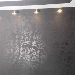 usługi ogólnobudowlane u Ilony - Szara ściana z dekoracyjną fakturą, oświetlona punktowymi lampami sufitowymi