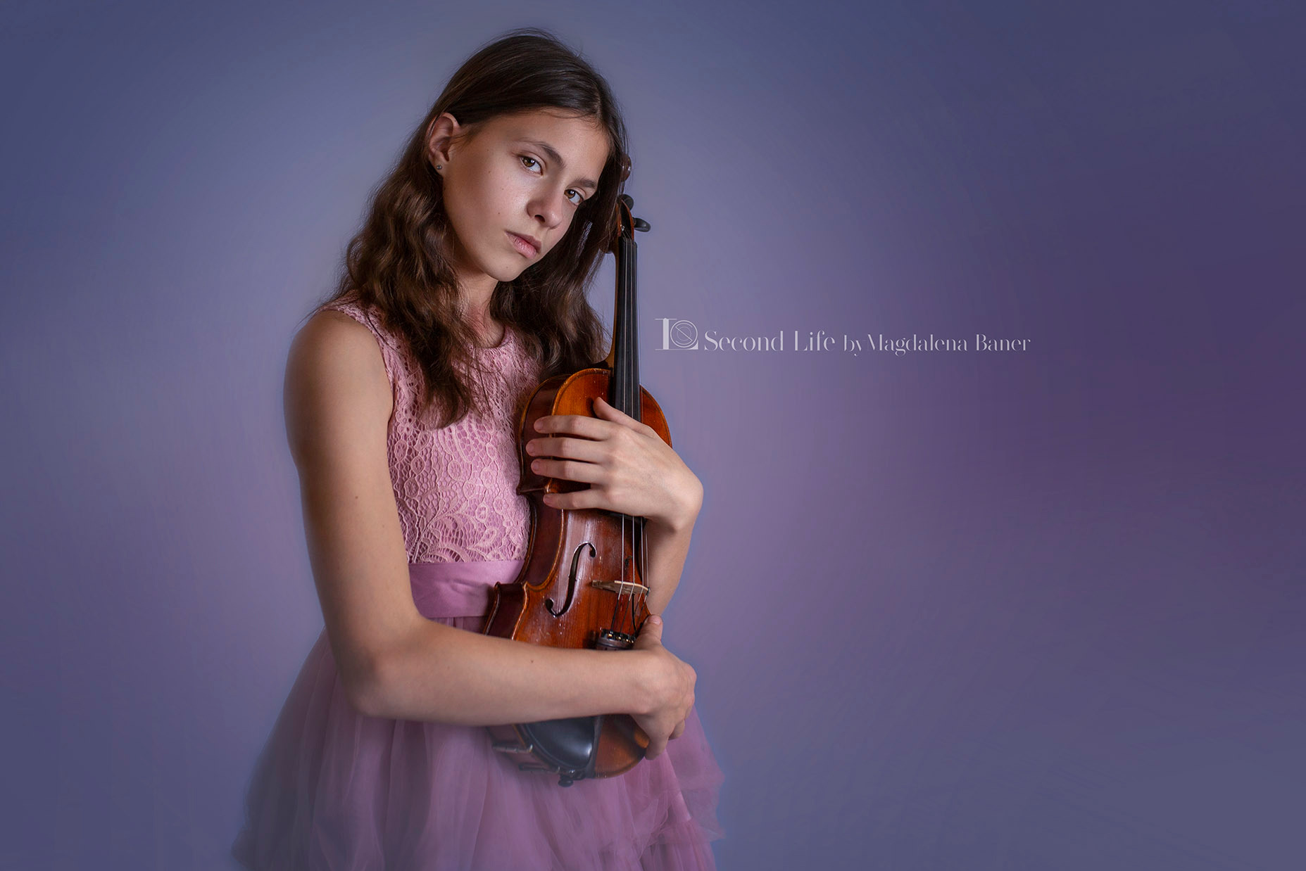 Młoda dziewczyna w różowej sukience trzyma skrzypce na fioletowym tle, spoglądając w obiektyw z poważnym wyrazem twarzy.