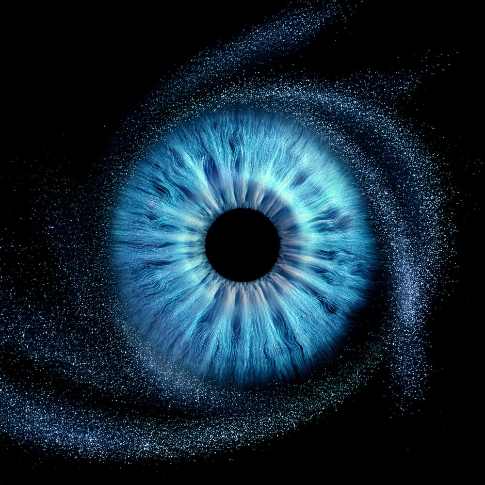Niebieskie oko z wirującym pyłem na czarnym tle, zbliżenie tęczówki z widocznymi włóknami.