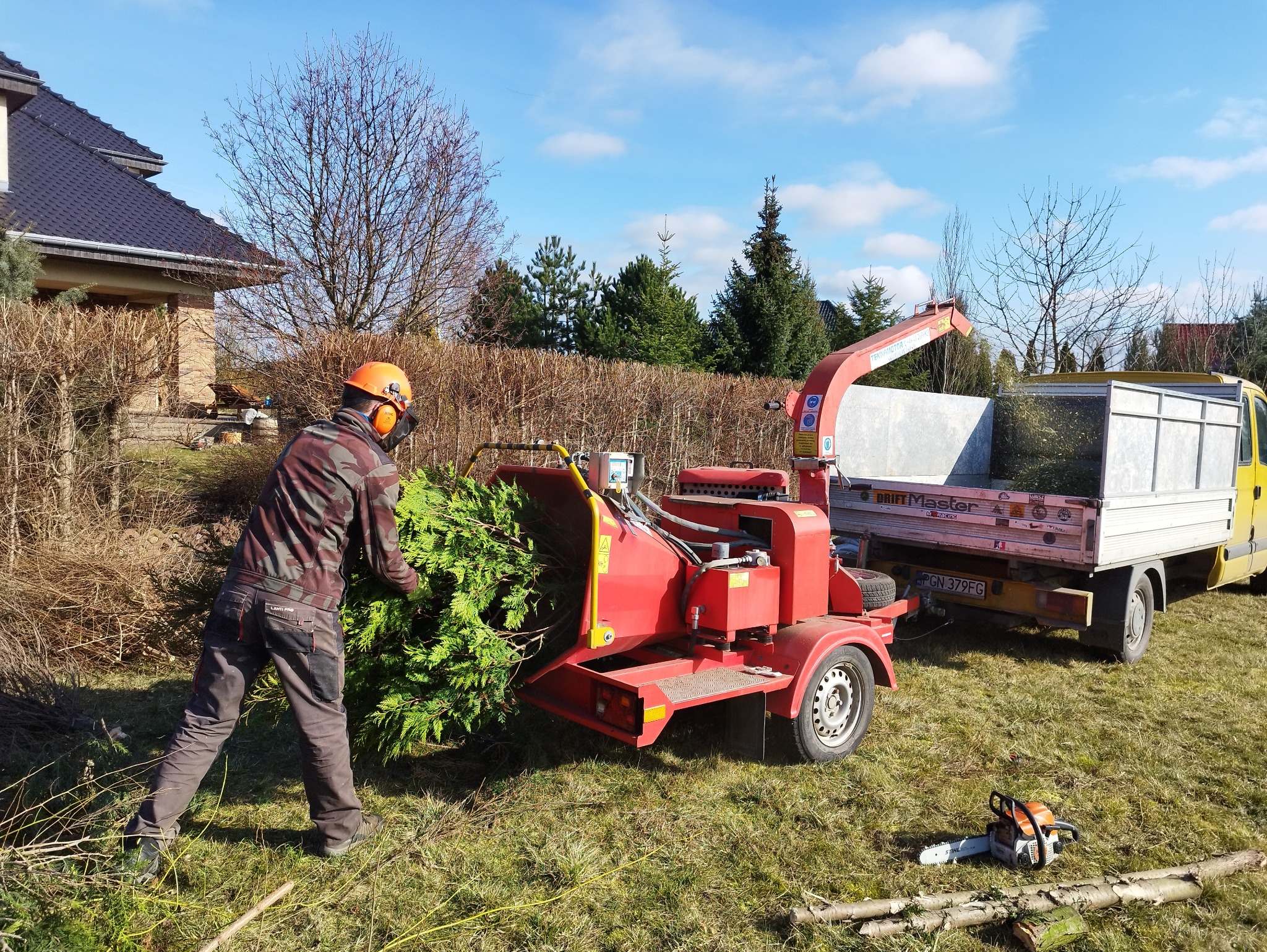 Sprzątanie gałęzi po wycince, duży rębak szybko je pochłania.