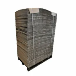 Stos tektury falistej, zabezpieczony taśmą, ułożony na palecie drewnianej, widok z boku na białym tle.