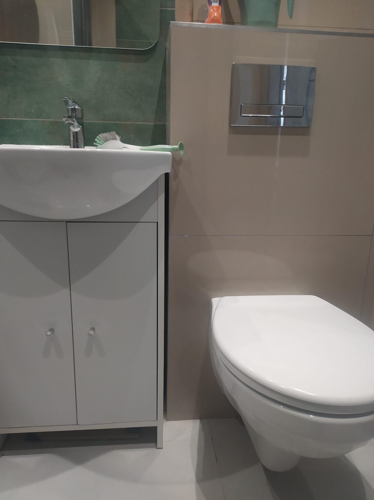 Nowoczesna, jasna łazienka w Bytomiu z podwieszaną toaletą, umywalką z szafką i chromowaną armaturą.