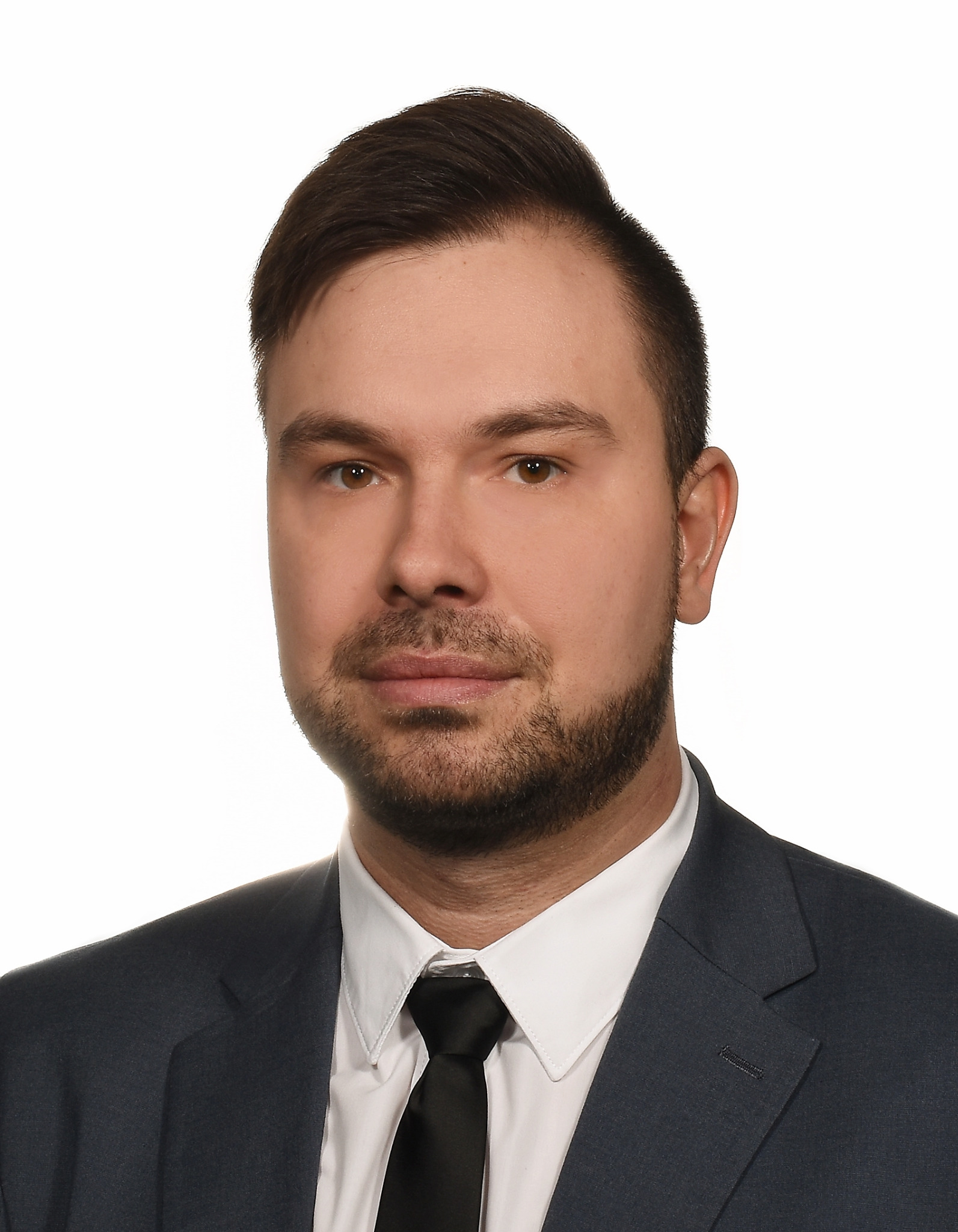 Portret mężczyzny w ciemnym garniturze i białej koszuli z czarnym krawatem, na białym tle.