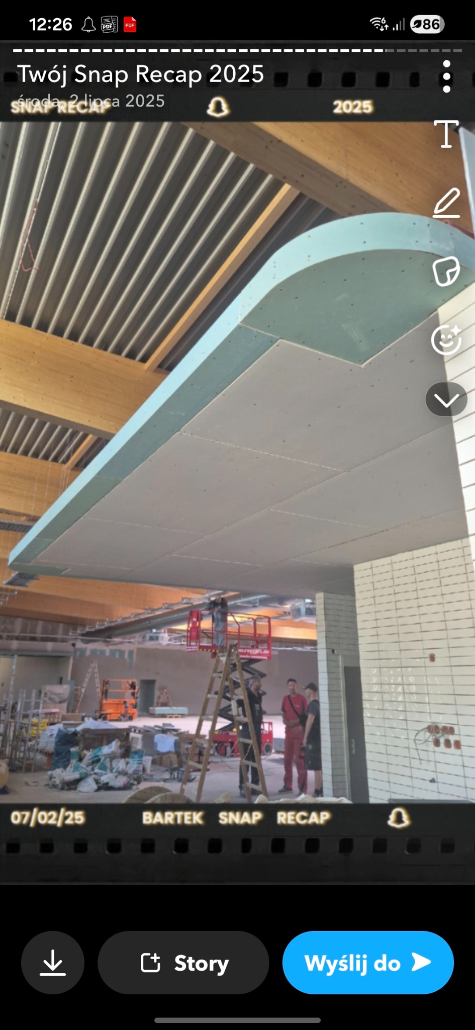 Montaż sufitu podwieszanego z płyt kartonowo-gipsowych w dużej przestrzeni. Widoczne rusztowania i ekipa montażowa. Elementy drewniane konstrukcji dachu.