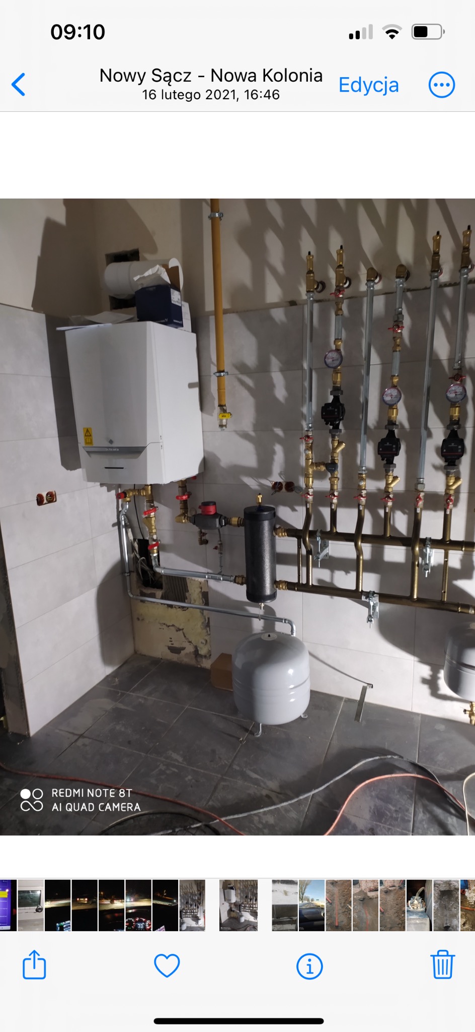 Nowa instalacja centralnego ogrzewania z kotłem kondensacyjnym, zbiornikiem wyrównawczym i rozdzielaczem z pompami obiegowymi, widoczne rury miedziane i manometry.