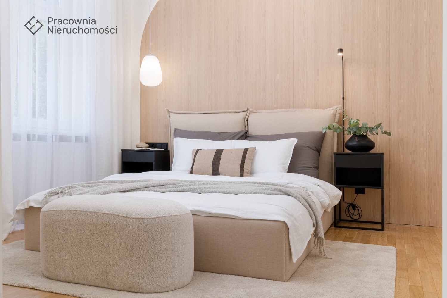Jasna sypialnia w Krakowie w stylu minimalistycznym z łóżkiem, pufą i drewnianą ścianą z delikatnym oświetleniem punktowym.