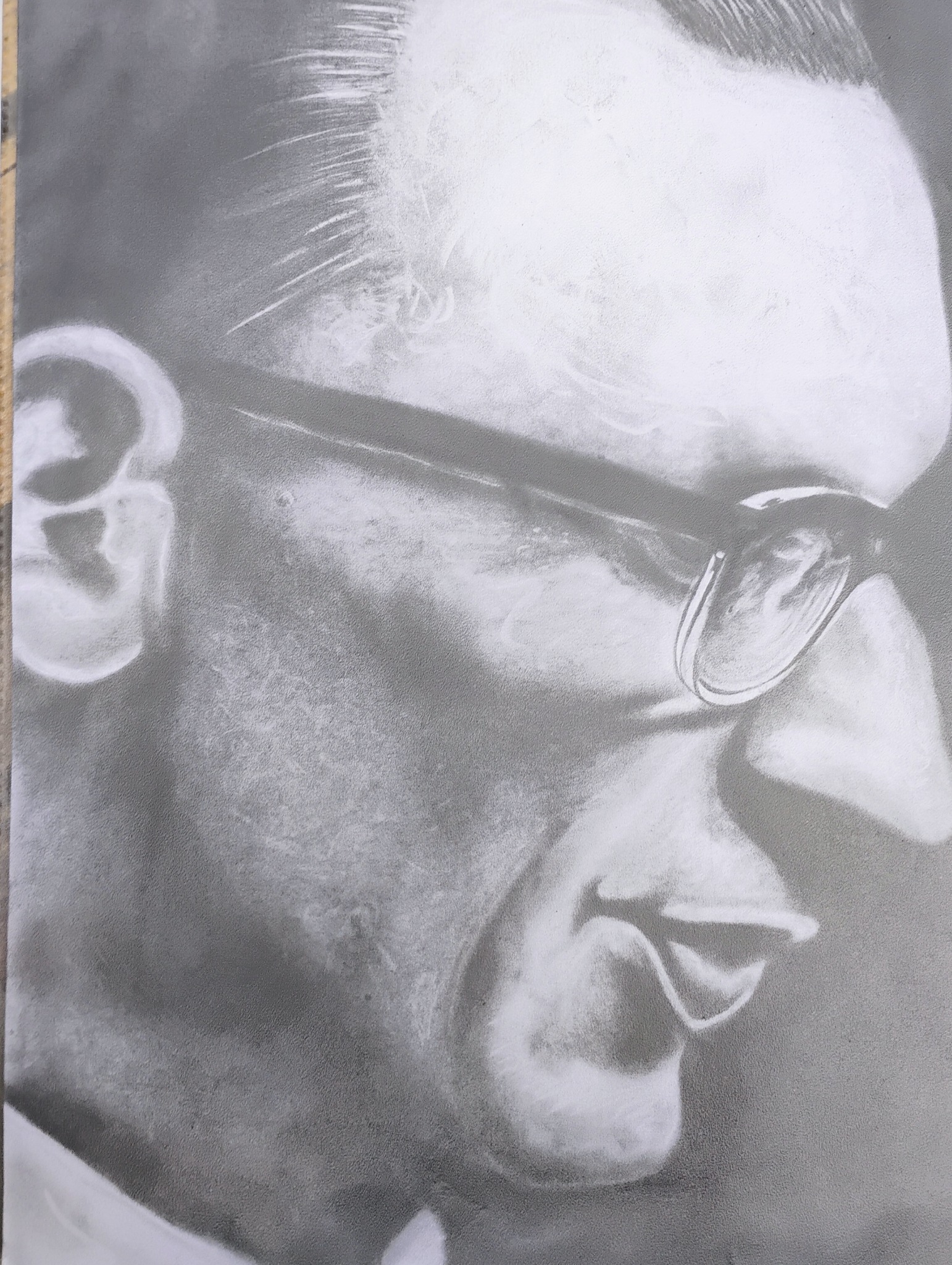 Czarno-biały portret mężczyzny w okularach, wykonany techniką malarską, widoczny z profilu, z delikatnymi detalami cieniowania.