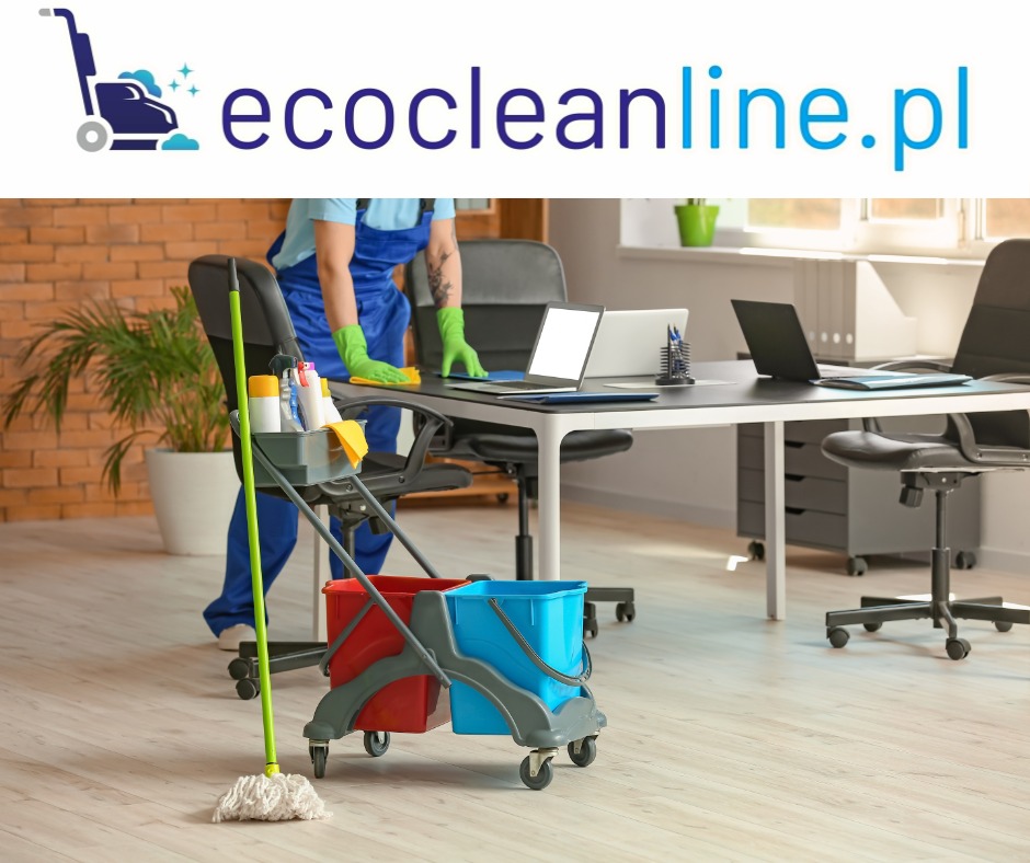 Pracownik w niebieskim kombinezonie i zielonych rękawicach przeciera biurko w biurze; w tle widoczne laptopy, krzesła biurowe i ceglana ściana; na pierwszym planie wózek z mopem i środkami czystości.