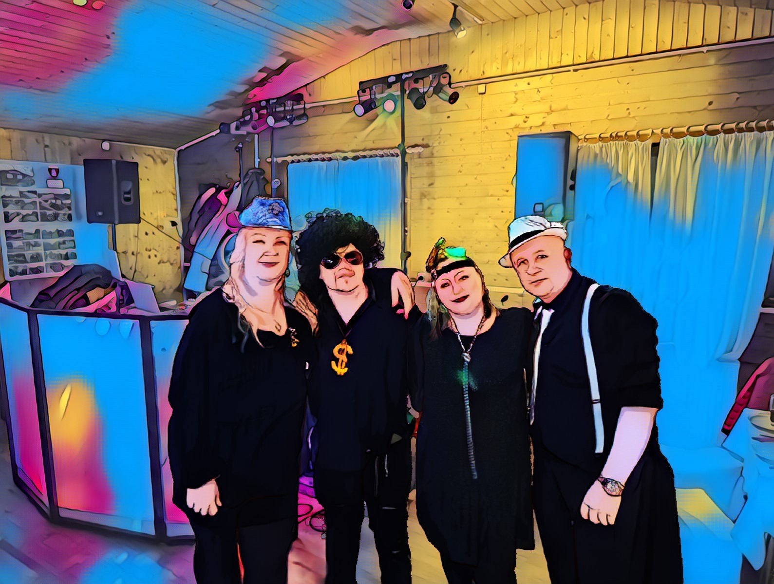 Czteroosobowa grupa w kostiumach na tle oświetlonej sceny z konsoletą DJ-a, stylizowana na imprezę tematyczną.