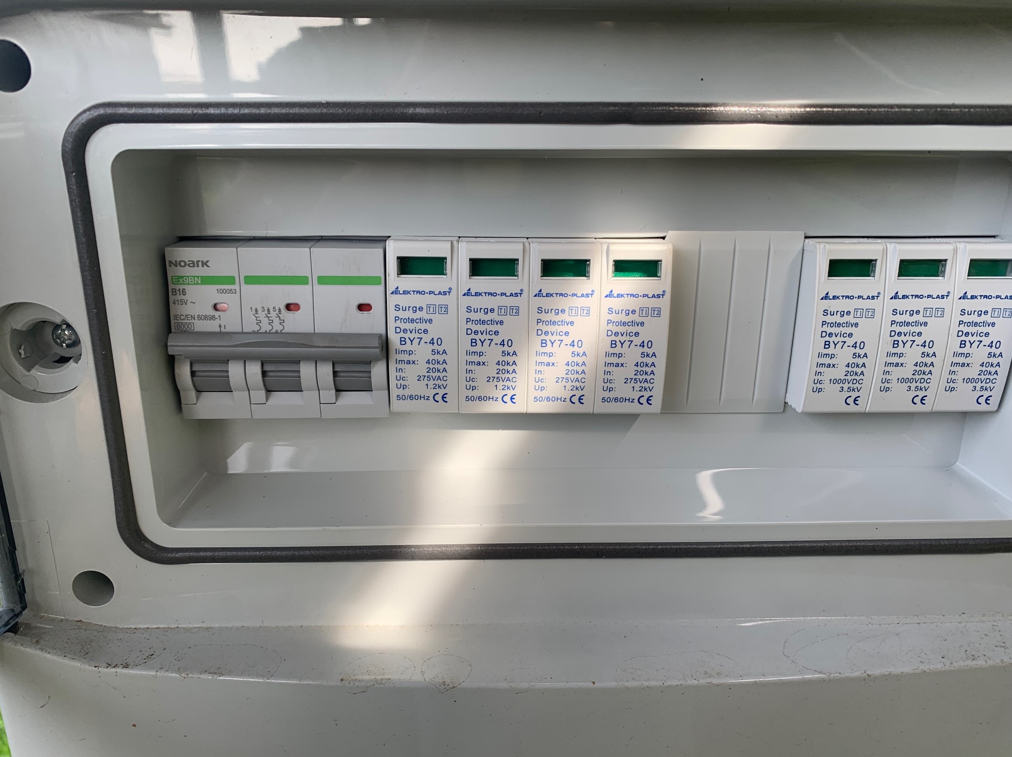 Szczegółowe ujęcie wnętrza skrzynki rozdzielczej z zamontowanymi ogranicznikami przepięć Elektro-Plast BY7-40 i wyłącznikiem Noark Ex9BN, widoczne parametry techniczne urządzeń.