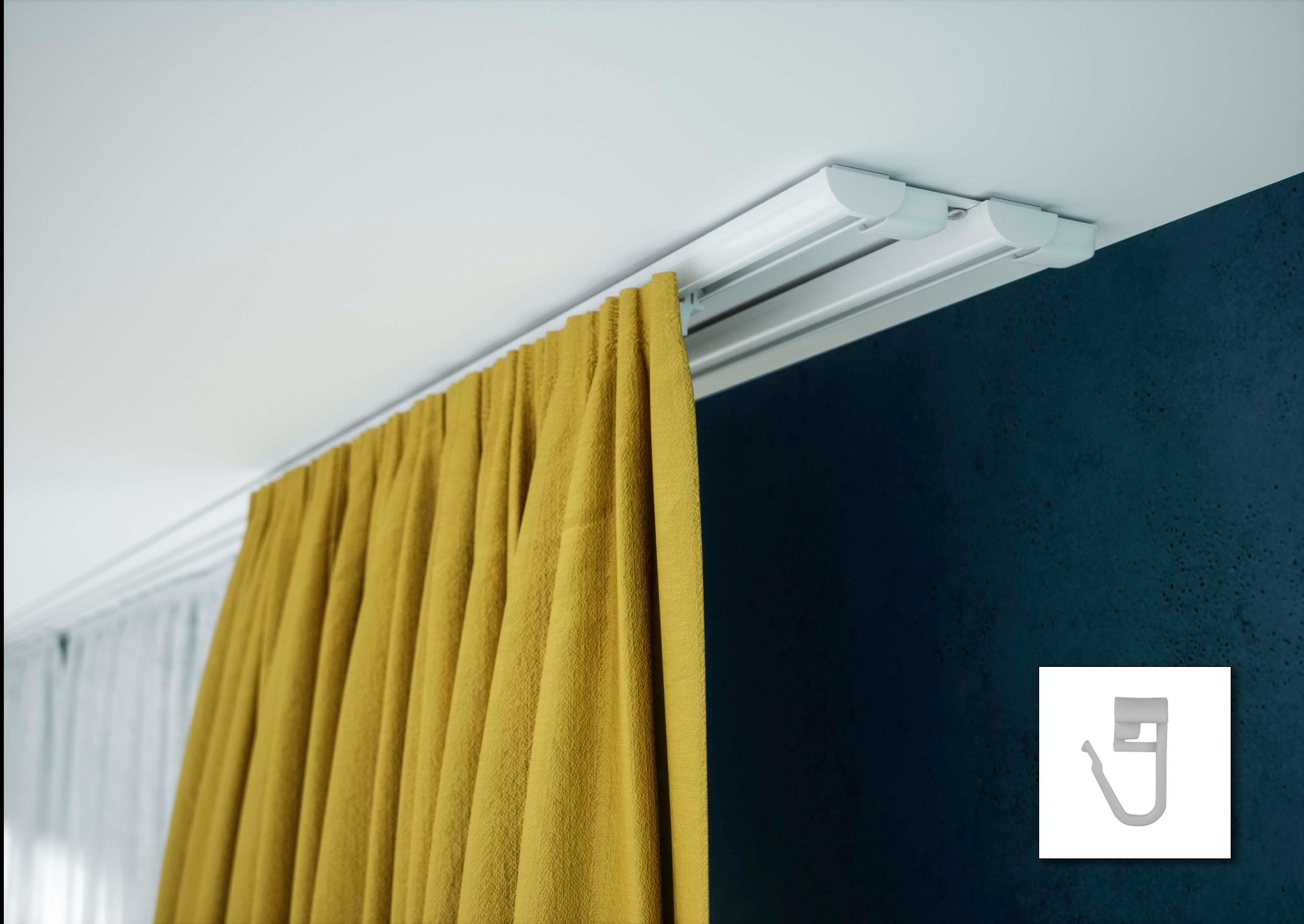 Żółta zasłona zawieszona na podwójnym, białym karniszu sufitowym, widoczne haczyki do mocowania tkaniny, ciemnoniebieska ściana w tle.
