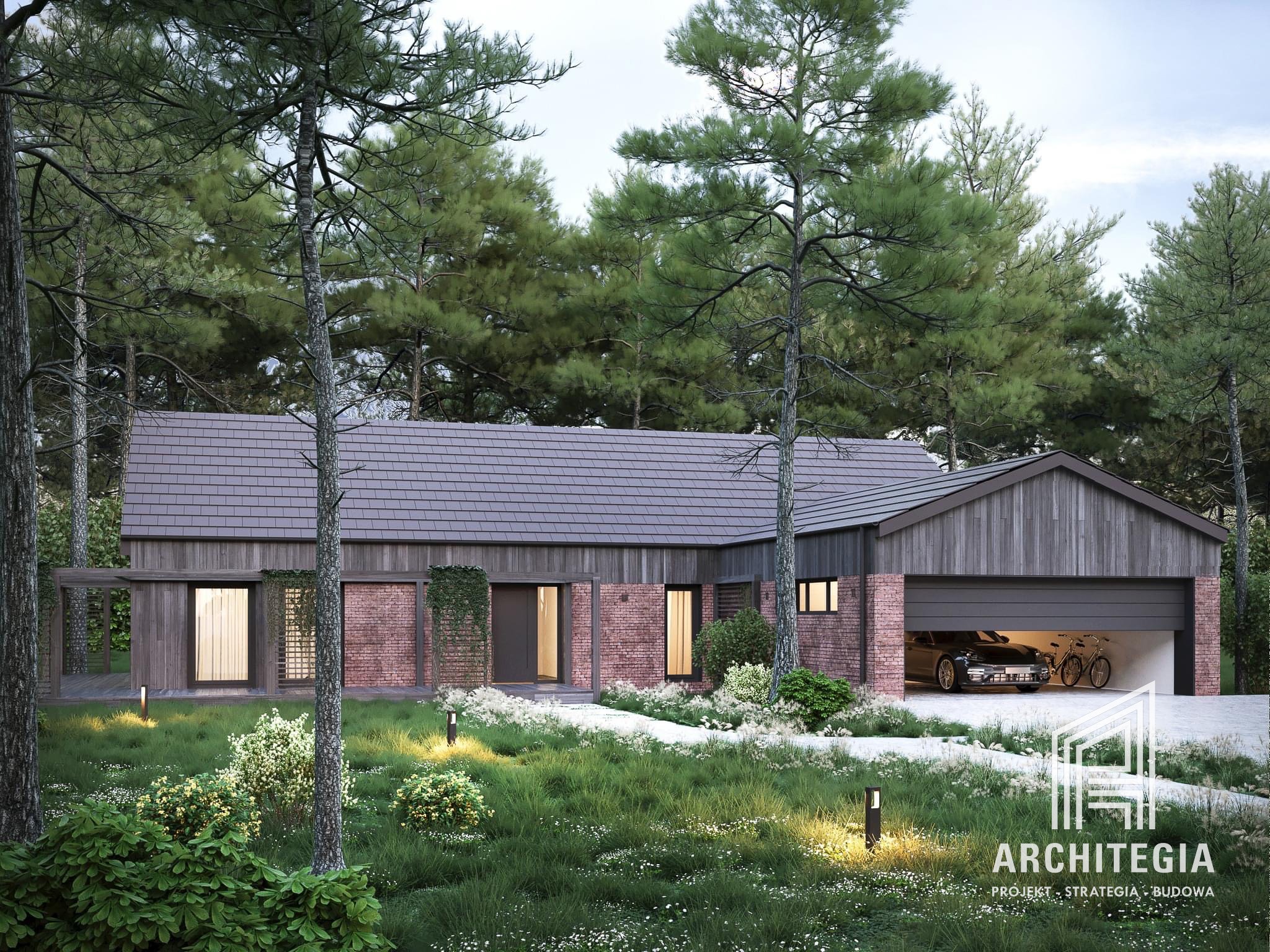 Nowoczesny dom z elementami cegły i drewna, otoczony zielenią, z garażem, w którym stoi samochód i rowery; widoczny logotyp firmy projektowej w prawym dolnym rogu.