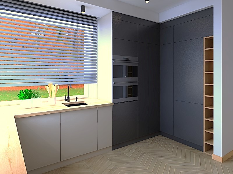 Nowoczesna kuchnia z szarymi szafkami, drewnianym blatem i oknem z żaluzjami, przez które widać jesienny krajobraz. Uwagę zwraca minimalistyczny design i oświetlenie.