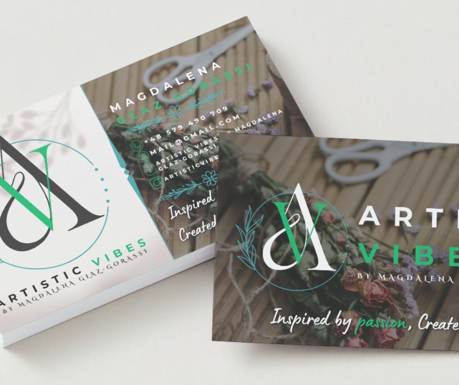 Dwie wizytówki z logo 'Artistic Vibes by Magdalena Glaz-Gorassi', jedna ułożona płasko, druga pod kątem, z widocznymi danymi kontaktowymi i hasłem 'Inspired by passion, Created', z elementami...