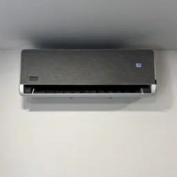 Szary klimatyzator VIVAX Inverter z wyświetlaczem 16.0, zamontowany na białej ścianie z delikatną fakturą. Widok z przodu, oświetlenie naturalne.