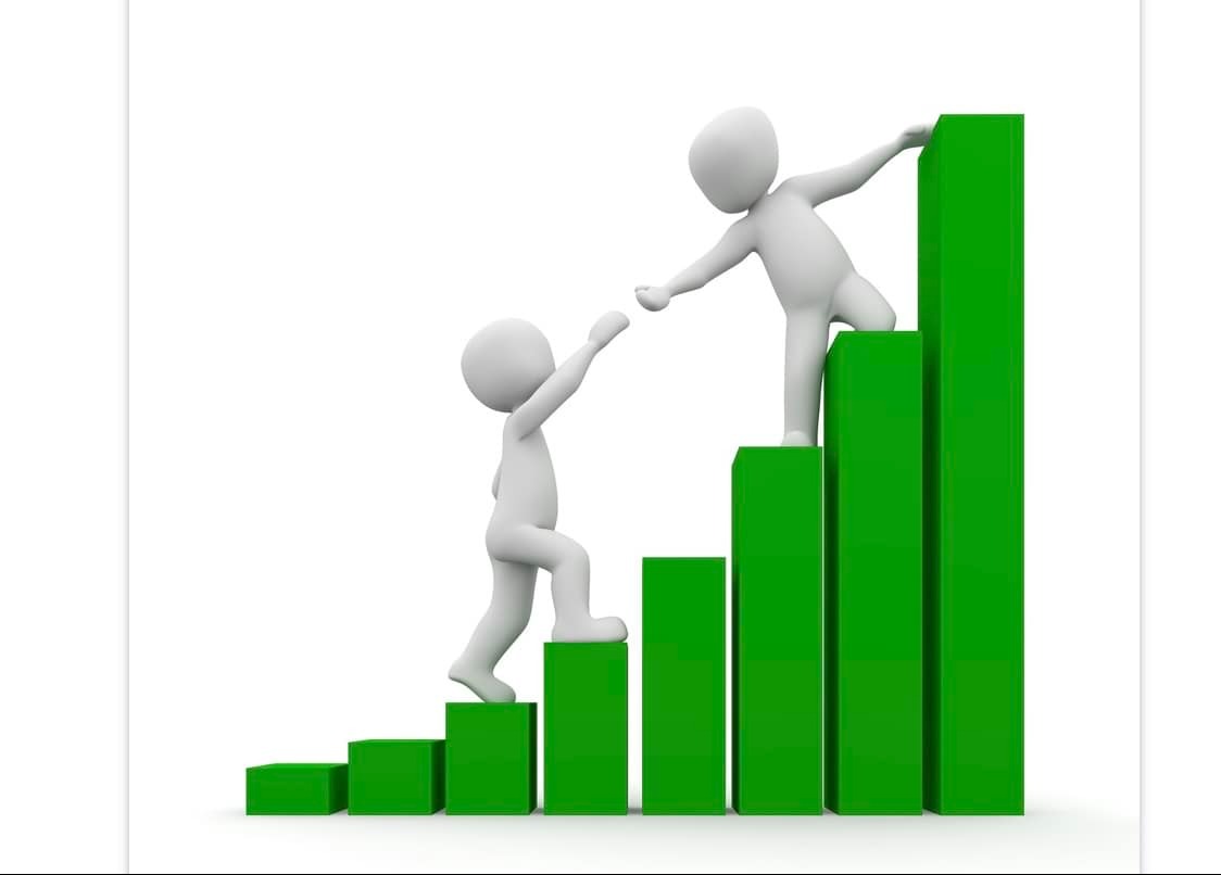 Stylizowana grafika przedstawia dwie białe figurki wspinające się po zielonym wykresie słupkowym; jedna figurka wyciąga rękę, by pomóc drugiej we wspinaczce.