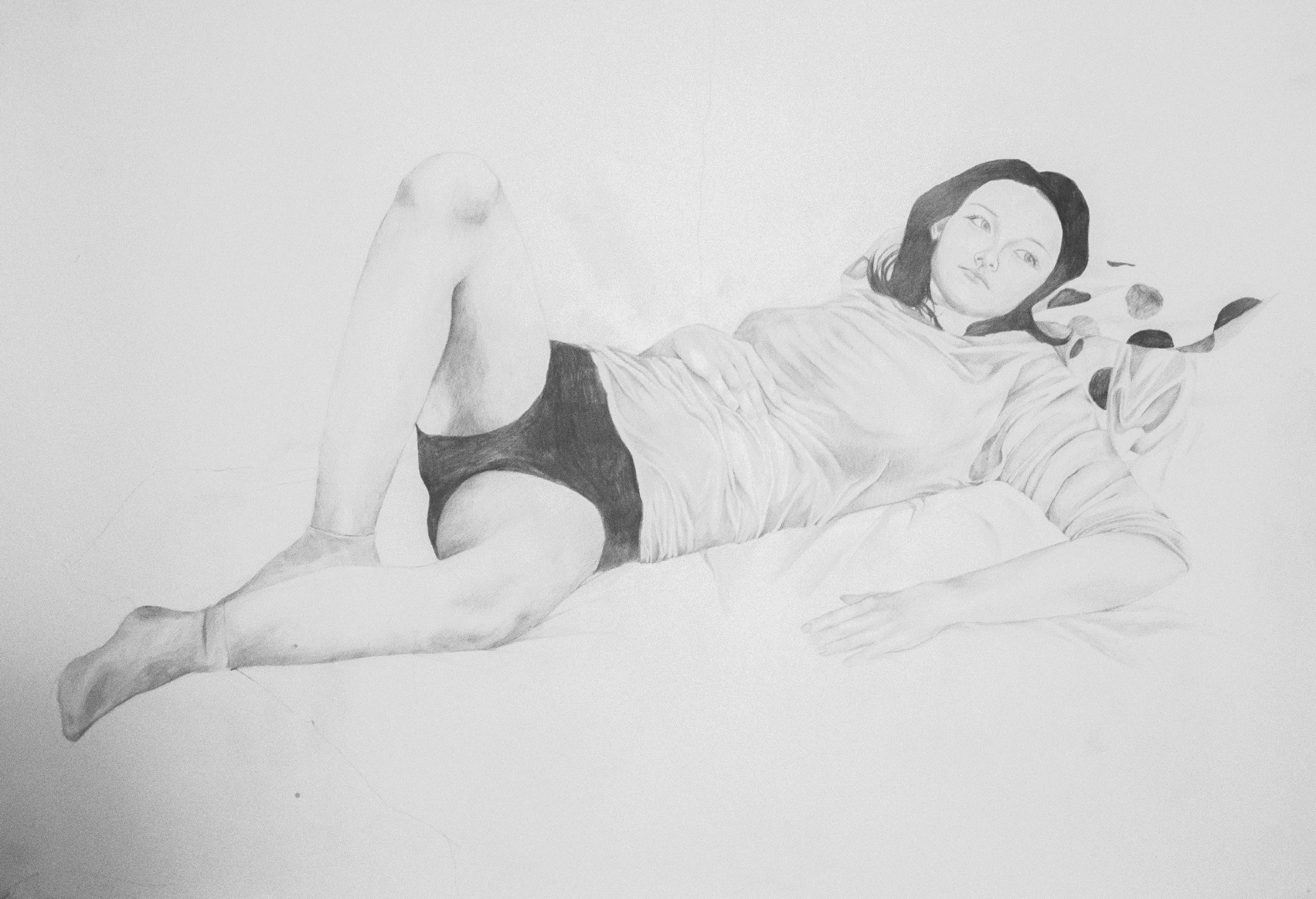 Szkic ołówkiem przedstawia leżącą kobietę w bieliźnie i bluzie. Delikatne cieniowanie podkreśla detale figury i fałdy ubrania. Subtelny realizm w monochromatycznej tonacji.