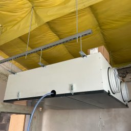 Concept4Energy - Montaż rekuperatora pod sufitem w Legnicy, widoczne przewody i elementy mocujące do sufitu z izolacją.
