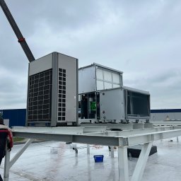 Concept4Energy Arkadiusz Godek - Montaż przemysłowej klimatyzacji na dachu budynku Panattoni, widoczny dźwig i pracownicy w odblaskowych kurtkach.