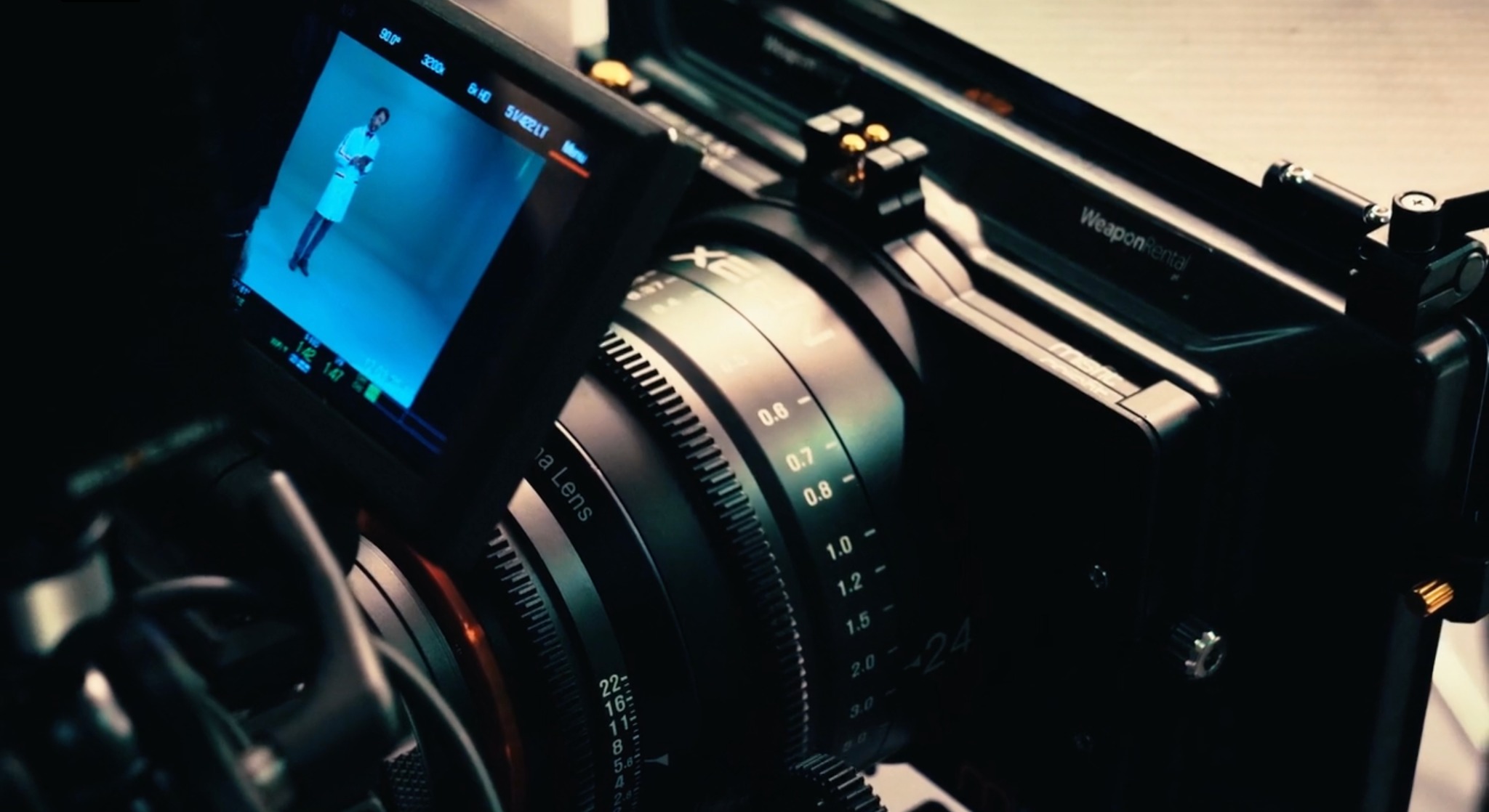 Profesjonalna kamera filmowa z widocznym ekranem podglądowym, na którym widoczna jest postać w białym stroju. Sprzęt używany przez firmy z Gliwic.