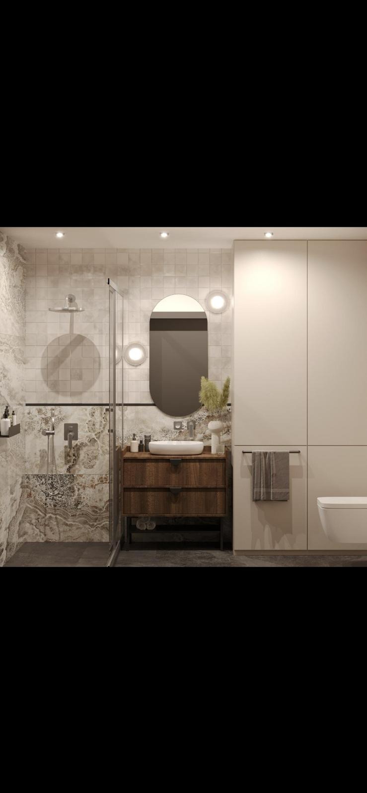 Nowoczesna łazienka z kabiną prysznicową typu walk-in, drewnianą szafką pod umywalką z blatem w kolorze białym, owalnym lustrem podświetlanym lampami i beżowymi płytkami imitującymi marmur...