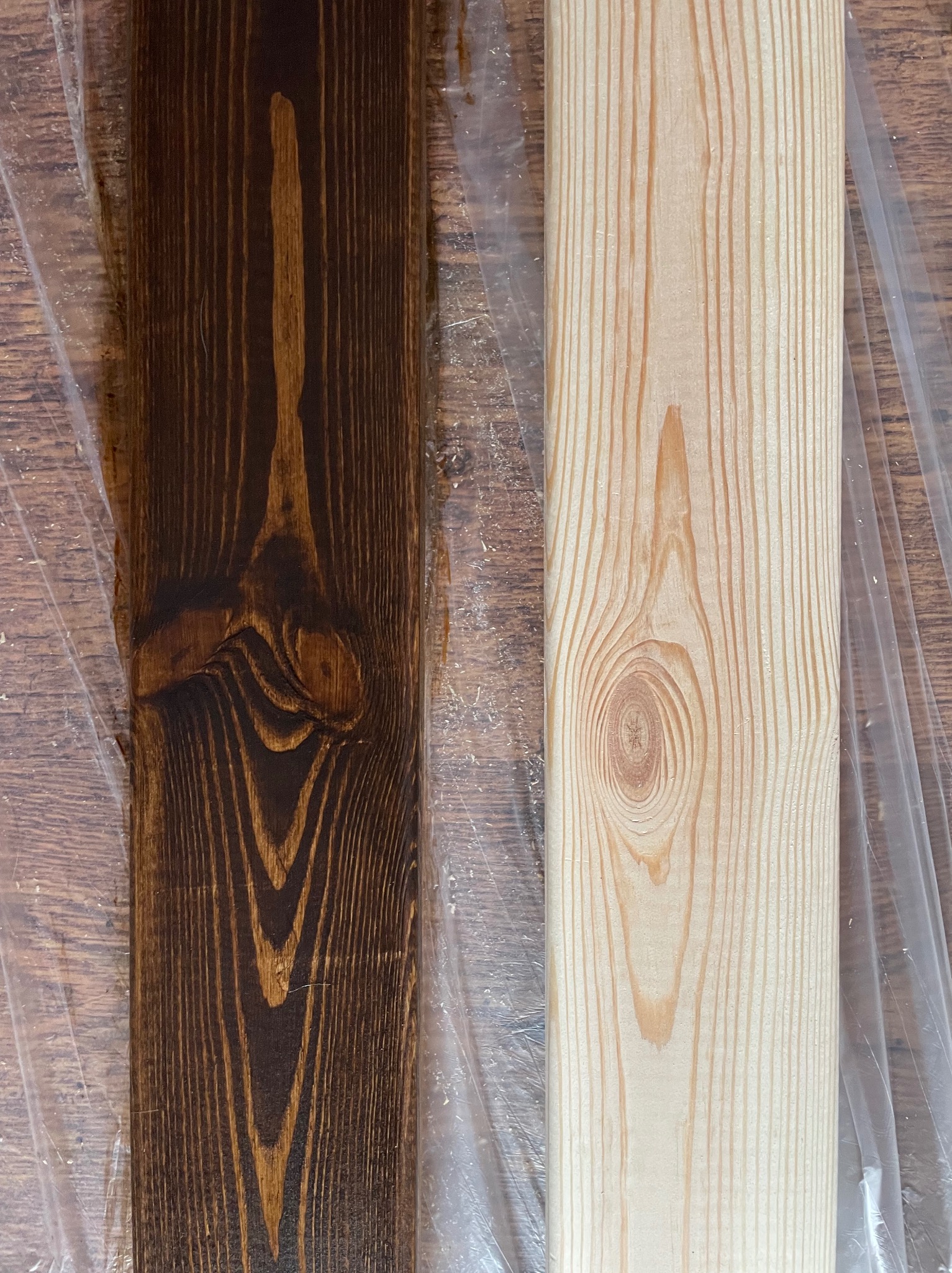 Deska sosnowa: surowa po prawej i bejcowana na ciemny brąz po lewej, ułożone na folii ochronnej.