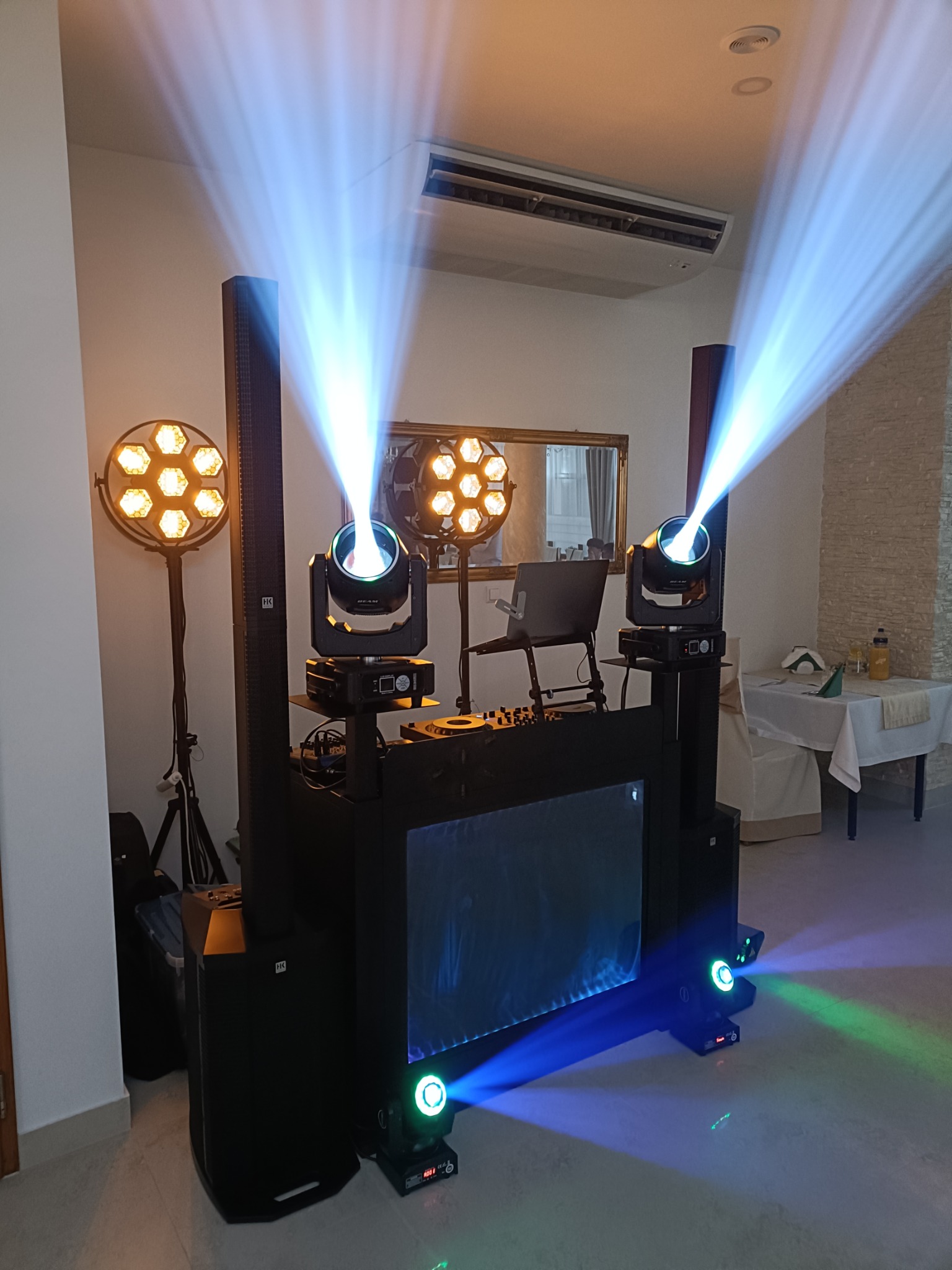 Profesjonalny zestaw nagłośnieniowy z efektownym oświetleniem scenicznym, w tym reflektory punktowe i kolumny głośnikowe, gotowy do obsługi imprezy.