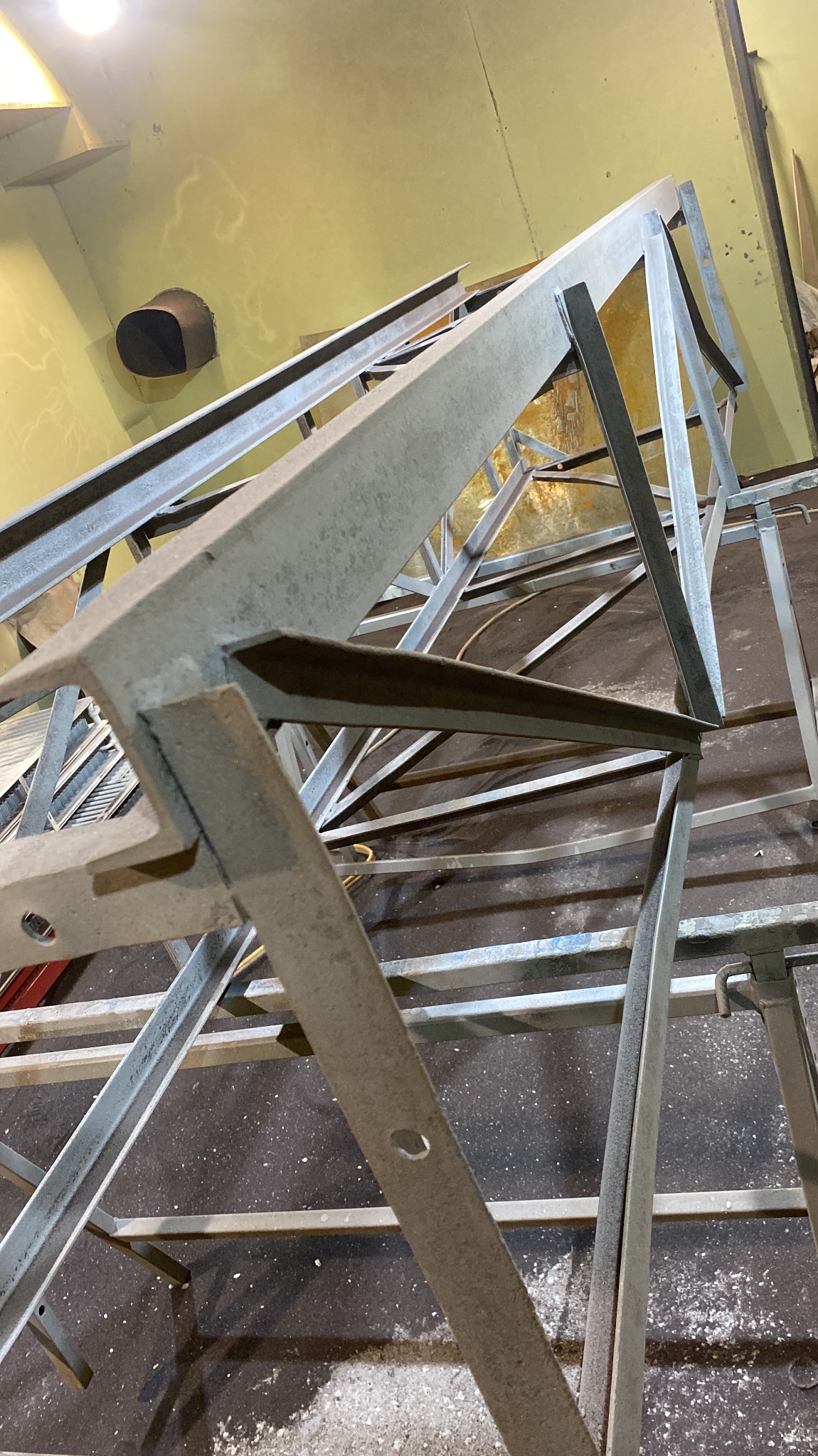 Konstrukcja stalowa z profili, spawana, surowa, widoczna w warsztacie, z bliska, pod kątem, w trakcie tworzenia.