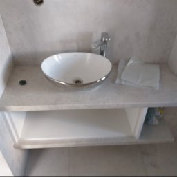 Proprofesional - Nowoczesna łazienka: biała umywalka nablatowa z chromowanym rantem, bateria i marmurowy blat z półką, białe ręczniki, instalacja elektryczna w ścianie.