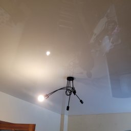Proprofesional - Błyszczący sufit po malowaniu, widoczne odbicie lampy i ślady po zabezpieczeniu folią malarską.