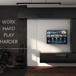 KORANTI Izabela Kornacka - Nowoczesna aranżacja pokoju z siłownią: czarna ściana z napisem, sprzęt do ćwiczeń, telewizor i minimalistyczne meble w odcieniach czerni i bieli.