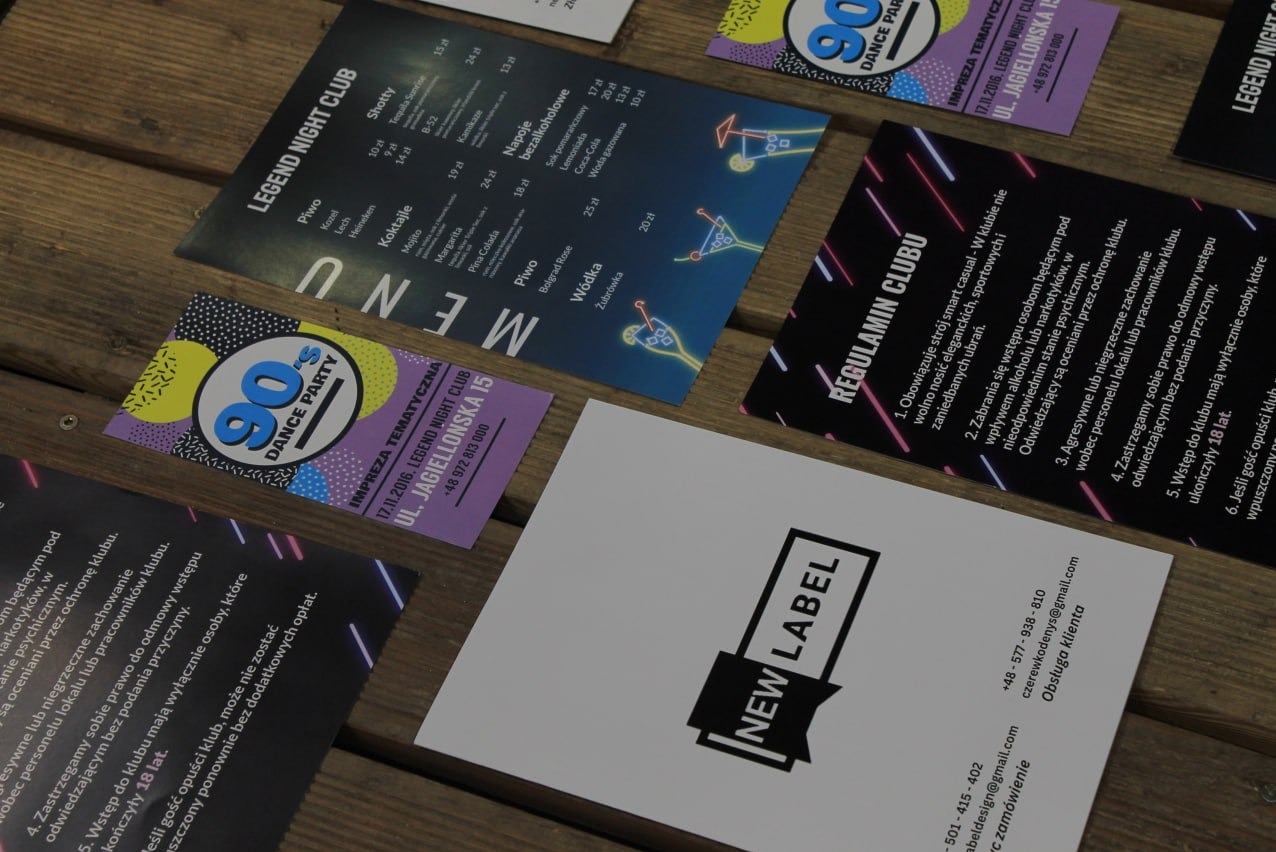 Różnorodne materiały drukowane, w tym menu klubu nocnego, ulotka imprezy tematycznej w stylu lat 90. i wizytówka z logo 'NEW LABEL', ułożone na drewnianym tle.
