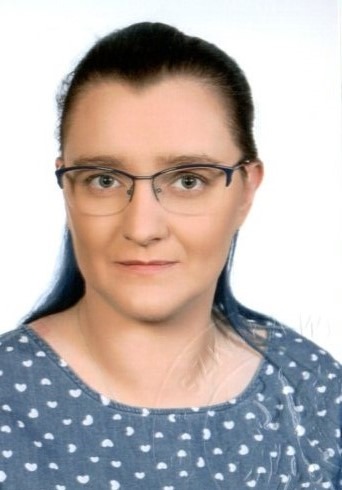 Portret kobiety w okularach, ubrana w bluzkę w białe serduszka, na białym tle.