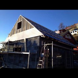 TREDOM BUDOWA DOMÓW SZKIELETOWYCH MAGDALENA SZWECH, SŁAWOMIR SZWECH SPÓŁKA JAWNA - Budowa domu z bloczków w Gdyni na etapie wznoszenia ścian i konstrukcji dachu, widoczne rusztowania i drabina.