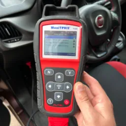 Diagnostyka TPMS w samochodzie Fiat przy użyciu skanera Autel MaxiTPMS TS508, wyświetlającego dane czujników ciśnienia w oponach na ekranie.