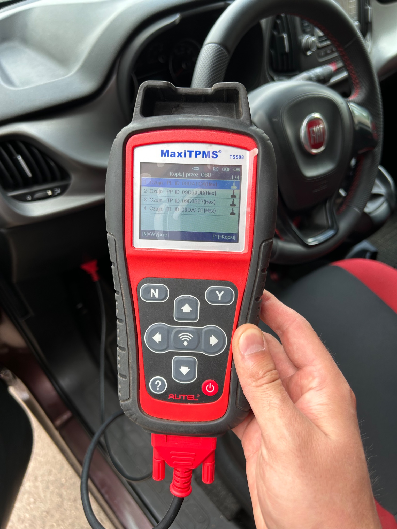 Diagnostyka TPMS w samochodzie Fiat przy użyciu skanera Autel MaxiTPMS TS508, wyświetlającego dane czujników ciśnienia w oponach na ekranie.