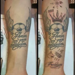 Ramię z serią czarno-szarych tatuaży: piłka nożna ze skrzydłami, korona, kompas z piłką, wilk, spadająca piłka, napis 'Freedom' i inne.