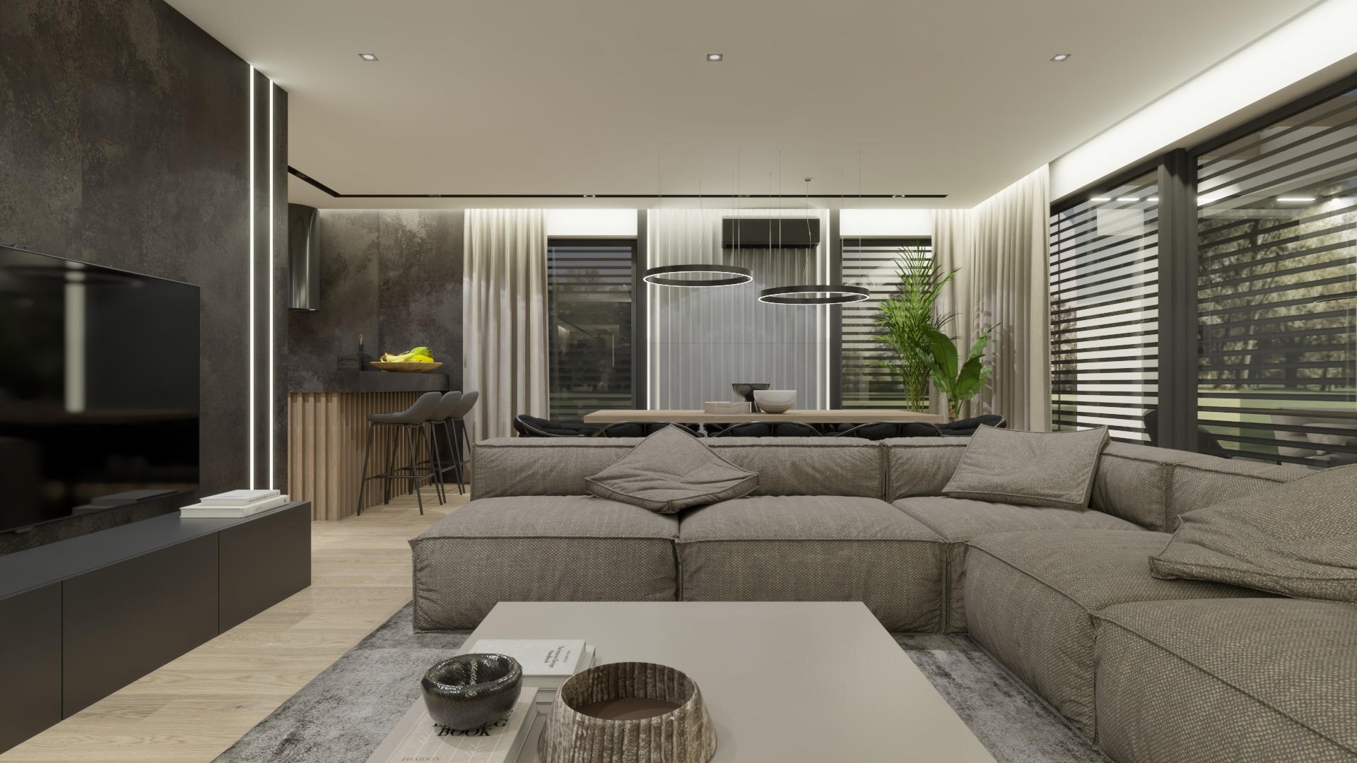 Nowoczesny salon z szarą, modułową sofą, niskim stolikiem kawowym, otwartą kuchnią z barkiem i wiszącymi lampami pierścieniowymi nad stołem jadalnym.