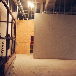 Olszówka - Wnętrze w trakcie prac wykończeniowych w Ciechanowie, widoczna konstrukcja ścian z płyt OSB, ściana przygotowana do malowania oraz podnośnik nożycowy.