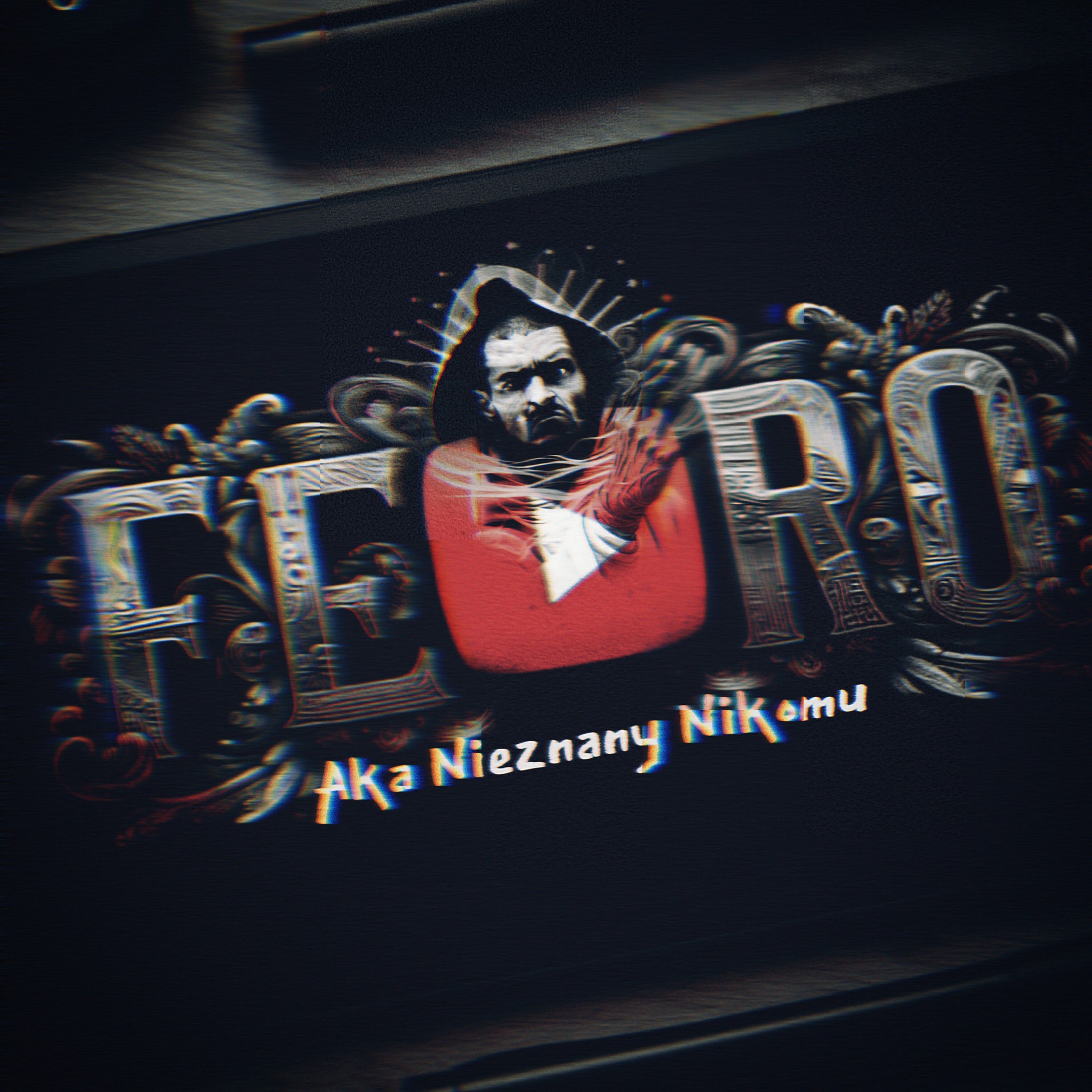 Grafika z wizerunkiem postaci w kapturze i napisem 'FEERO Aka Nieznany Nikomu' w ozdobnej czcionce, utrzymana w ciemnej kolorystyce z efektem glitch art.