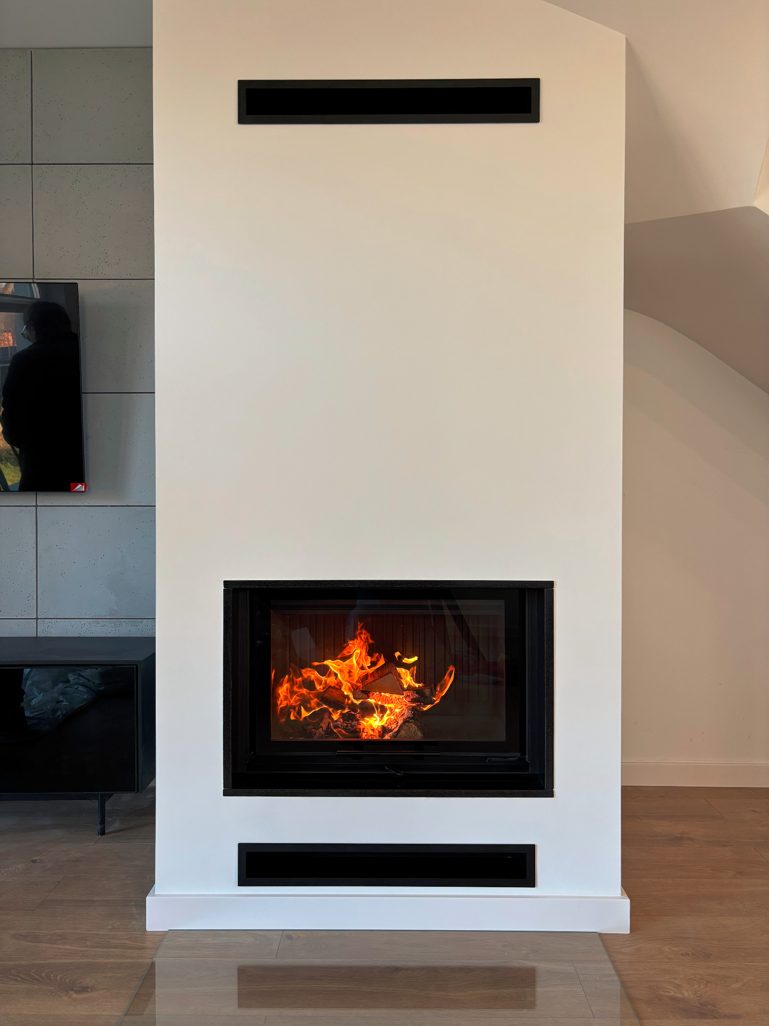 Aranżacja nowoczesnej bryły kominka przy schodach