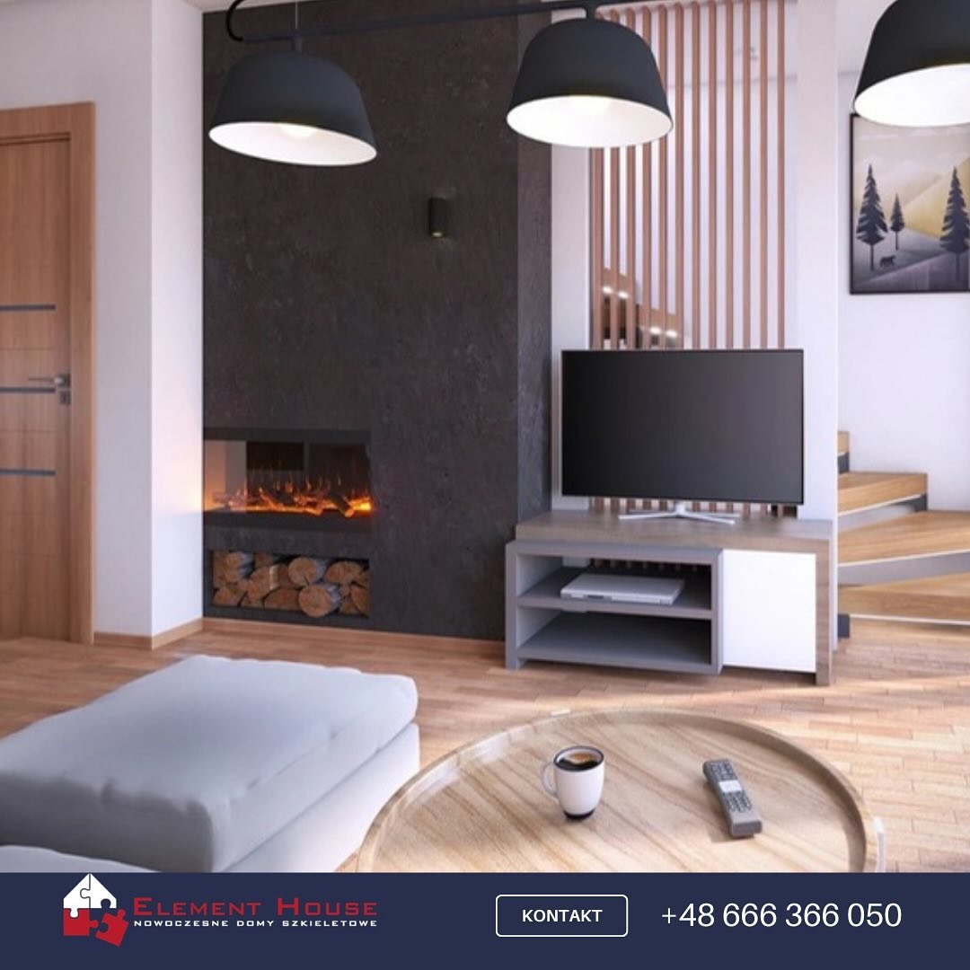 Nowoczesny salon z kominkiem elektrycznym i drewnem, telewizor na szafce RTV, okrągły stolik kawowy z filiżanką, schody drewniane w tle.