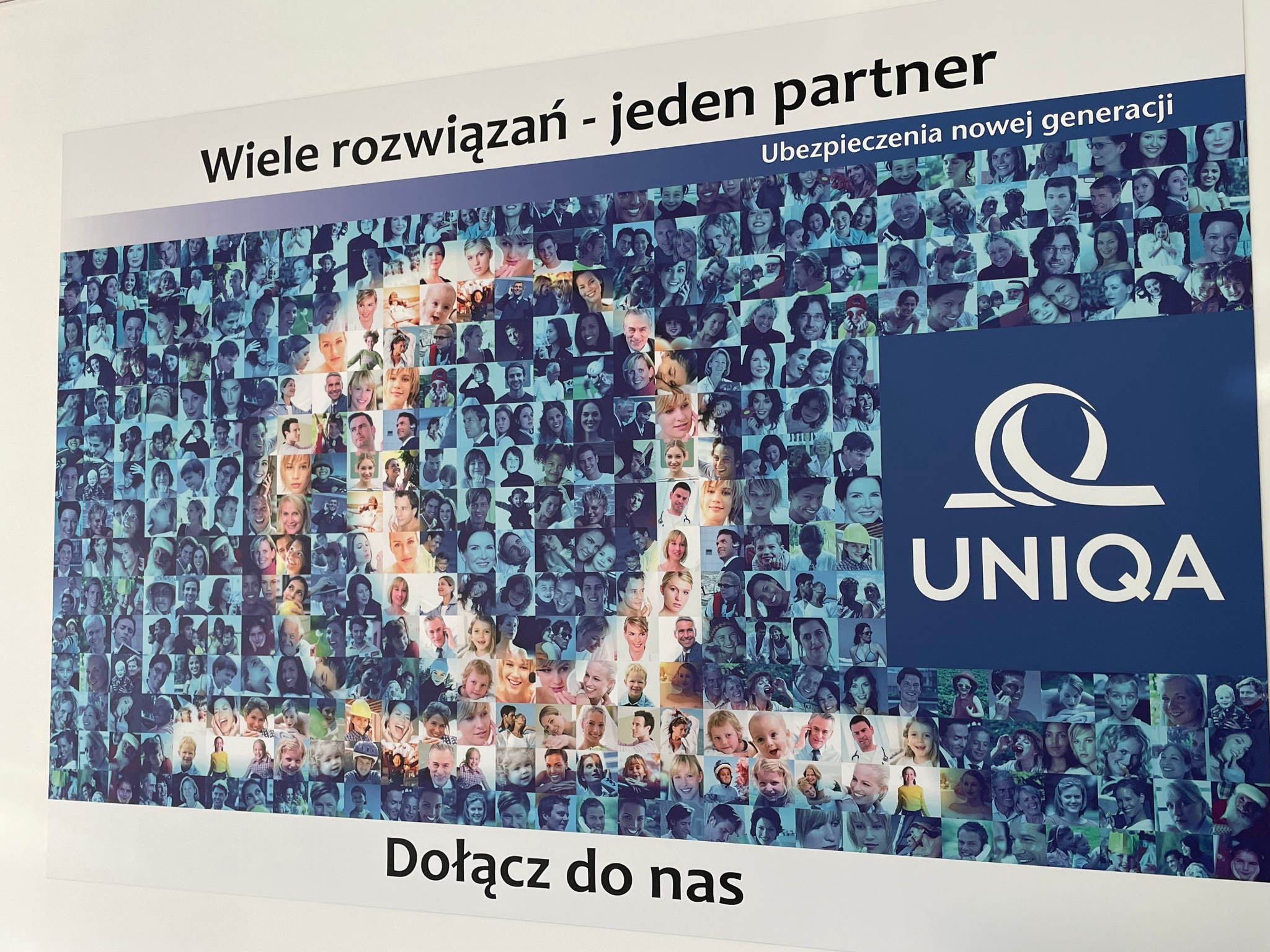Plakat reklamowy z kolażem zdjęć różnych osób, hasłem 'Wiele rozwiązań - jeden partner' oraz logo firmy UNIQA.
