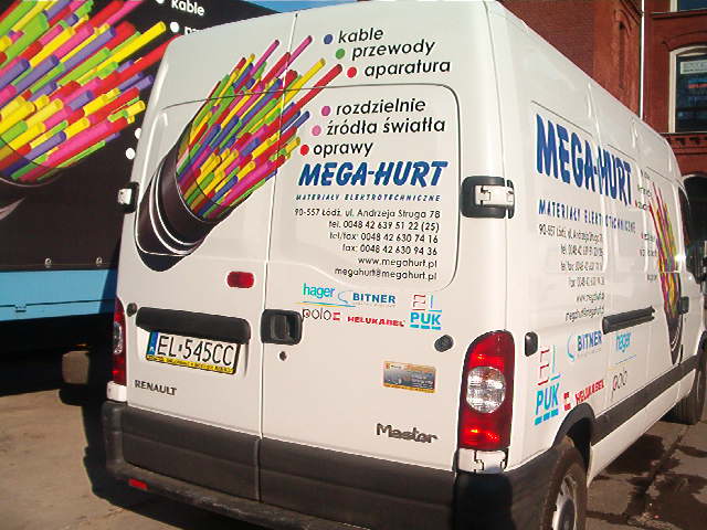Biały samochód dostawczy Renault Master z reklamą firmy Mega-Hurt, prezentujący grafikę kabla światłowodowego z kolorowymi przewodami na tylnych drzwiach oraz logo i dane kontaktowe firmy na bokach.